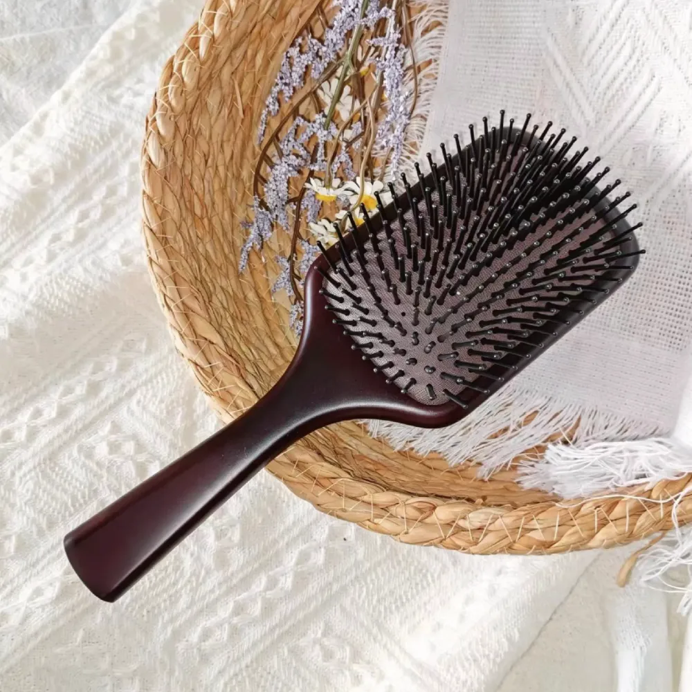 AIRMEI paddle hairbrush lying in woven basket with fabric
