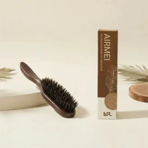 BSFL Pear Wood Boar Bristle Hair Styling Brush on a wooden surface with balm